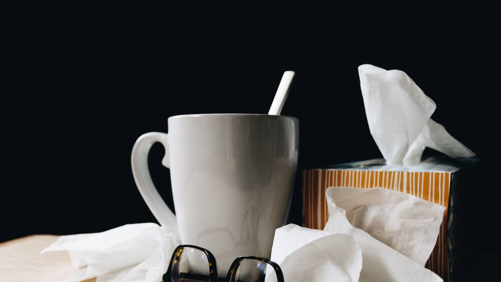 Tissues, mug and reading glasses collected during illness